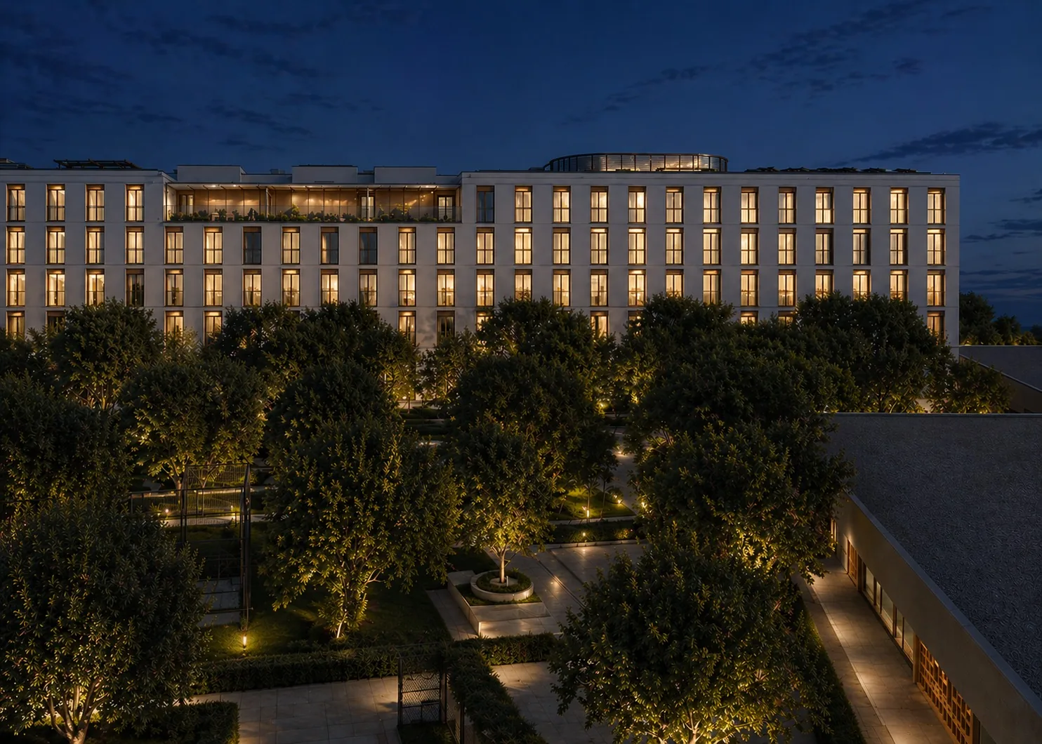 Rendu nocturne de Vik Living avec le bâtiment illuminé au-dessus du jardin